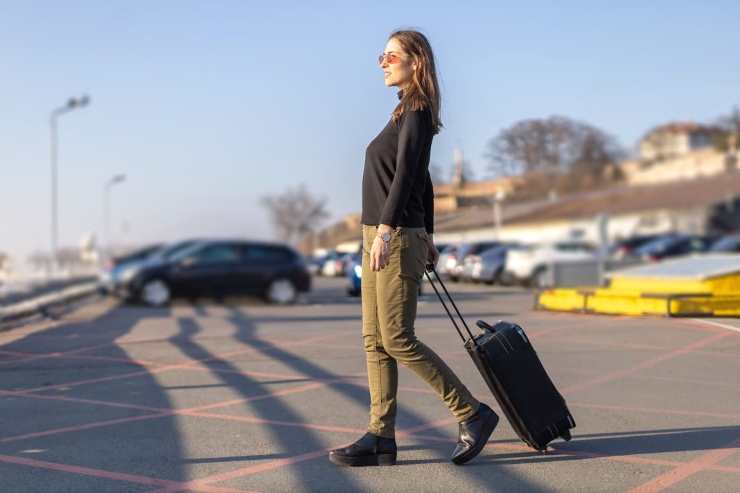 se garer à l'aéroport de Toulouse woman walking with suitcase on parking place