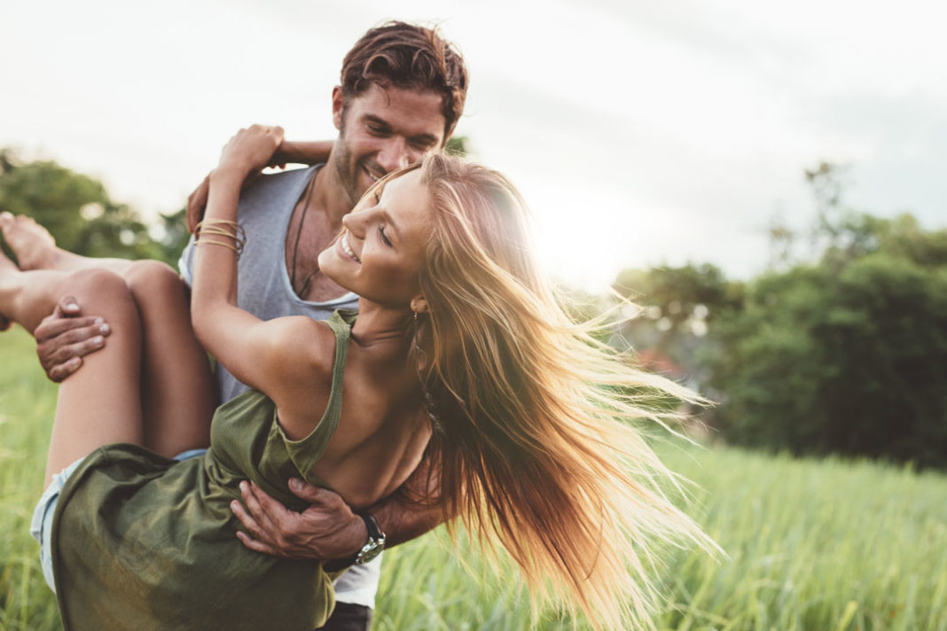 UN couple dans la nature, leurs beaux cheveux volent au vent